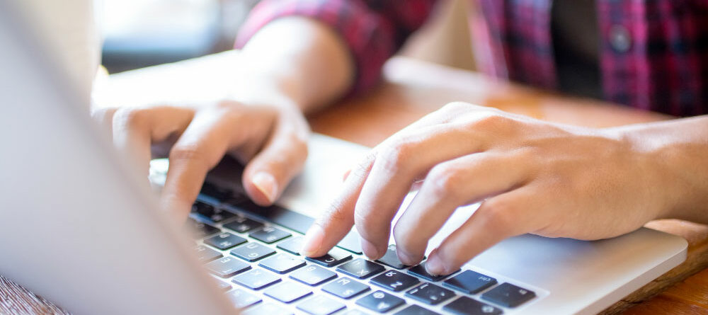 close-up-of-female-student-typing-on-laptop-at-table close-up-of-female-student-typing-on-laptop-at-table